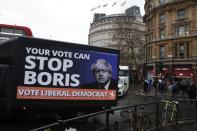 A vehicle brandishing an election campaign poster for the Liberal Democrats party, drives in Trafalgar Square in London, Tuesday, Dec. 10, 2019. Britain goes to the polls on Thursday, Dec. 12. (AP Photo/Thanassis Stavrakis)