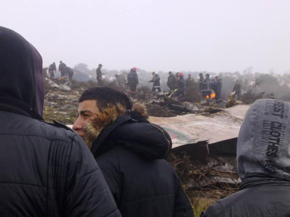 People watch rescue workers working at the wreckage of an Algerian military transport aircraft after it slammed into a mountain in the country’s rugged eastern region, Tuesday, Feb. 11, 2014. A civil defense official said 102 people on board were killed but one person managed to survive. The U.S.-built C-130 Hercules transport crashed about noon near the town of Ain Kercha, 50 kilometers (30 miles) southeast of Constantine, the main city in eastern Algeria. ( AP Photo/ Mohamed Ali)