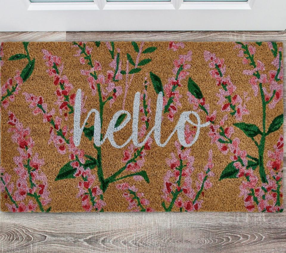 the mat with the word "hello" written on it and pink and green flowers