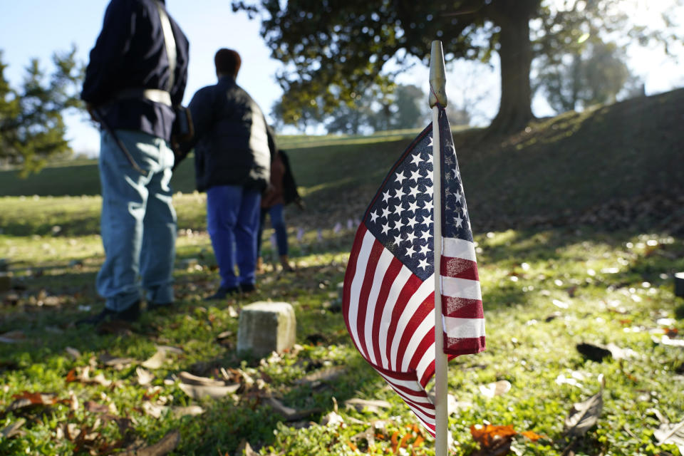 A small American flag marks the grave of a Civil War soldier of the United States 1st Mississippi Infantry (African Descent) in Vicksburg National Cemetery, Feb. 14, 2024, in Vicksburg, Miss. Thirteen flags were placed at the graves of Black soldiers killed in 1864 in a massacre at Ross Landing, Arkansas, who were buried as unknowns but have recently been identified. (AP Photo/Rogelio V. Solis)