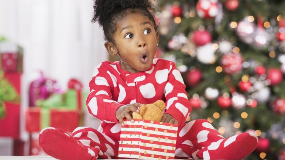 Una niña sorprendida con un regalo.