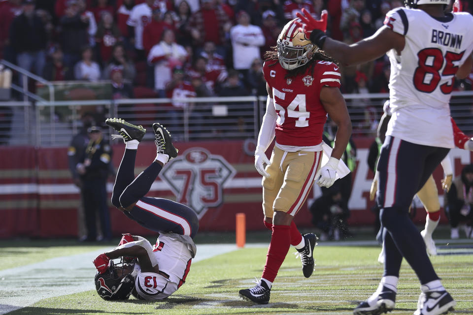 Houston Texans wide receiver Brandin Cooks (13) rolls backward in the end zone after scoring a touchdown next to San Francisco 49ers middle linebacker Fred Warner (54) during the first half of an NFL football game in Santa Clara, Calif., Sunday, Jan. 2, 2022. (AP Photo/Jed Jacobsohn)