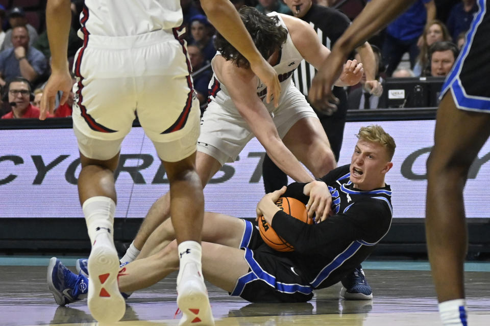 BYU guard Richie Saunders, bottom center, grabs the ball against Saint Mary's during the first half of an NCAA college basketball game in the semifinals of the West Coast Conference men's tournament Monday, March 6, 2023, in Las Vegas. (AP Photo/David Becker)