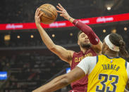 Cleveland Cavaliers' Max Strus, left, looks to shoot over Indiana Pacers' Myles Turner (33) during the first half of an NBA basketball game in Cleveland, Friday, April 12, 2024. (AP Photo/Phil Long)