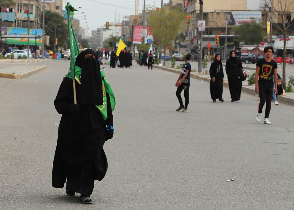 Although shrines are closed due to the new coronavirus, Shiite pilgrims make their way to the shrine of Imam Moussa al-Kadhim, a key Shiite saint, during preparations for the annual commemoration of his death, in Baghdad, Iraq Friday, March 20, 2020. Iraq announced a weeklong curfew to help fight the spread of the virus. For most people, the virus causes only mild or moderate symptoms. For some it can cause more severe illness. (AP Photo/Hadi Mizban)