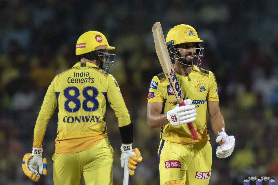 Chennai Super Kings' Ruturaj Gaikwad, right, raises his bat to acknowledge his fifty runs as Devon Conway looks at him during the Indian Premier League qualifier cricket match between Chennai Super Kings and Gujrat Titans in Chennai, India, Tuesday, May 23, 2023. (AP Photo /R. Parthibhan)