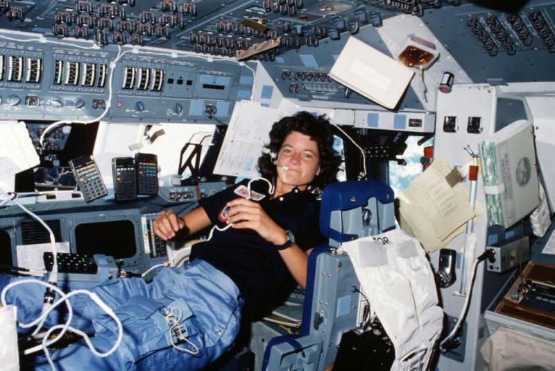 Astronaut Sally K. Ride, STS-7 mission specialist, performs a number of functions simultaneously, proving the necessity for versatility and dexterity in space travel. Floating freely on the flight deck, Dr. Ride communicates with ground controllers in Houston, moves within feet of important reference data, hand calculators and other aids all at the same time. NASA Photo