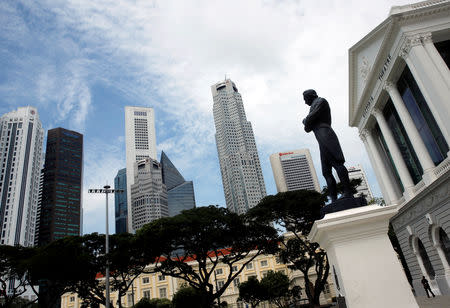 A man passes a statue of Sir Stamford Raffles next to the skyline of Singapore May 24, 2016. REUTERS/Edgar Su/Files