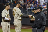 San Diego Padres starting pitcher Joe Musgrove hands his glove to the umpires to check for substances during the sixth inning of Game 3 of a National League wild-card baseball playoff series against the New York Mets, Sunday, Oct. 9, 2022, in New York. (AP Photo/John Minchillo)