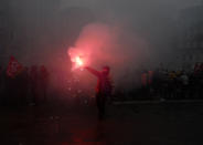 Rail worker light flares during a mass strike in Lille, northen France, Thursday, Dec. 5, 2019. Workers across the public sector fear President Emmanuel Macron's reform will force them to work longer and shrink their pensions. (AP Photo/Michel Spingler)