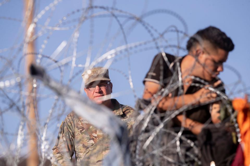 A Texas National Guard soldier tells migrants to return to Mexico as they try to get through concertina wire on the Texas bank of the Rio Grande last month.