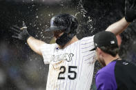 Teammates shower Colorado Rockies' C.J. Cron after he drove in the winning run against the Milwaukee Brewers in the 10th inning of a baseball game Friday, June 18, 2021, in Denver. The Rockies won 6-5. (AP Photo/David Zalubowski)