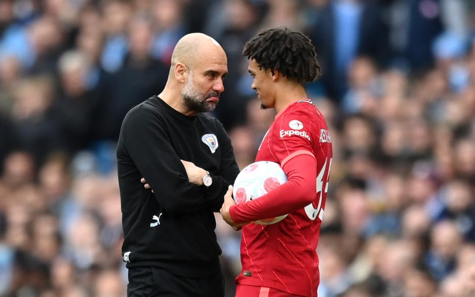 Trent Alexander-Arnold of Liverpool and Pep Guardiola, Manager of Manchester City share a joke during the Premier League match between Manchester City and Liverpool