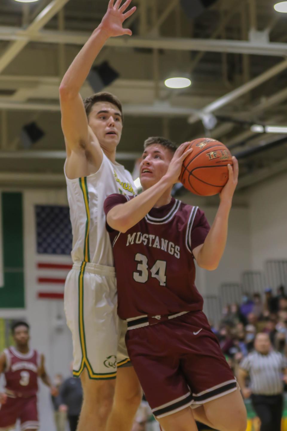 Salina Central's Ethan Waters (34) puts up a shot against Salina South's Zach Davidson (14) during Friday's game at the South gym.