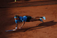 FILE - In this June 2, 2019, file photo, Greece's Stefanos Tsitsipas falls after diving to return a shot against Switzerland's Stan Wawrinka during their fourth round match of the French Open tennis tournament at Roland Garros stadium in Paris. (AP Photo/Christophe Ena, File)