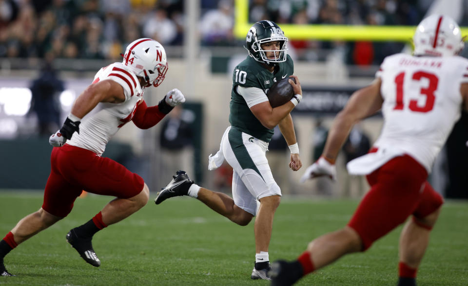 Michigan State quarterback Payton Thorne, center, scrambles against Nebraska's Garrett Nelson, left, and JoJo Domann (13) during the first quarter of an NCAA college football game, Saturday, Sept. 25, 2021, in East Lansing, Mich. (AP Photo/Al Goldis)