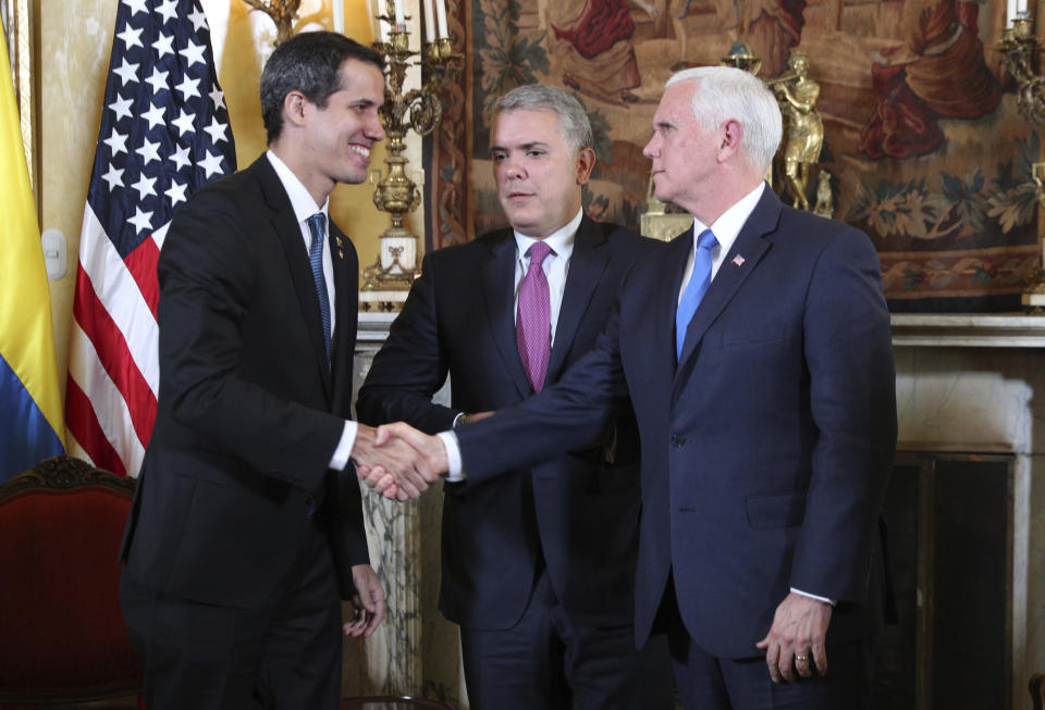 Venezuela's self-proclaimed interim president Juan Guaido, left, shakes with Vice President Mike Pence, after a meeting of the Lima Group concerning Venezuela at the Foreign Ministry in Bogota, Colombia, Monday, Feb. 25, 2019. Pence's appearance before the Lima Group comes two days after a U.S.-backed effort to deliver humanitarian across the border from Colombia ended in violence. Pictured in the center is Colombia's President Ivan Duque. (AP Photo/Martin Mejia)