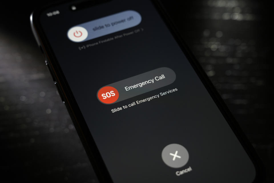 A button used to contact emergency services is seen on a mobile phone, Thursday, April 18, 2024, in St. Louis. Law enforcement agencies in Nebraska, Nevada, South Dakota and Texas reported temporary outages to 911 services on Wednesday before saying hours later that services had been restored. (AP Photo/Jeff Roberson)