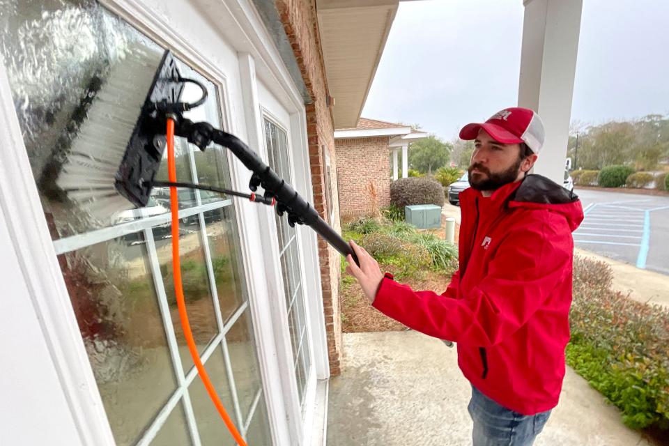 David Long with Fish Window Cleaning uses a water-powered brush to clean the windows of the club house at Children in Crisis' Children's Neighborhood. The company's entire team visited the Children's Neighborhood Thursday to clean windows in celebration of Random Act of Kindness Day.