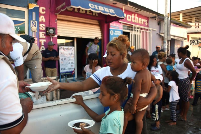 Honduran migrants, many with babies and small children, queue up to receive food