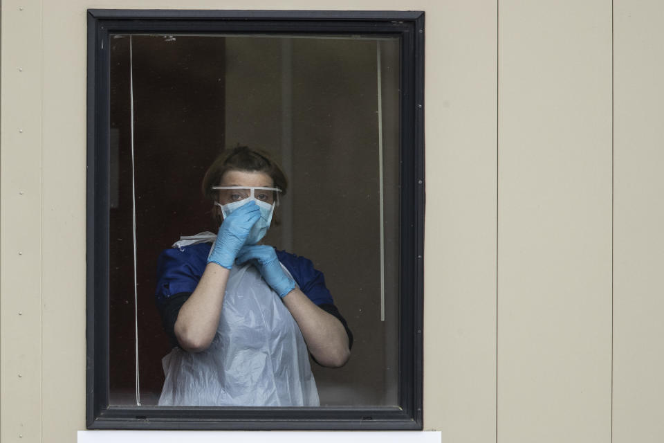 CHESSINGTON, ENGLAND  - MARCH 30: A nurse adjusts her face mask before taking swabs at a Covid-19 Drive-Through testing station for NHS staff on March 30, 2020 in Chessington, United Kingdom. The Coronavirus (COVID-19) pandemic has spread to many countries across the world, claiming over 30,000 lives and infecting hundreds of thousands more. (Photo by Dan Kitwood/Getty Images)