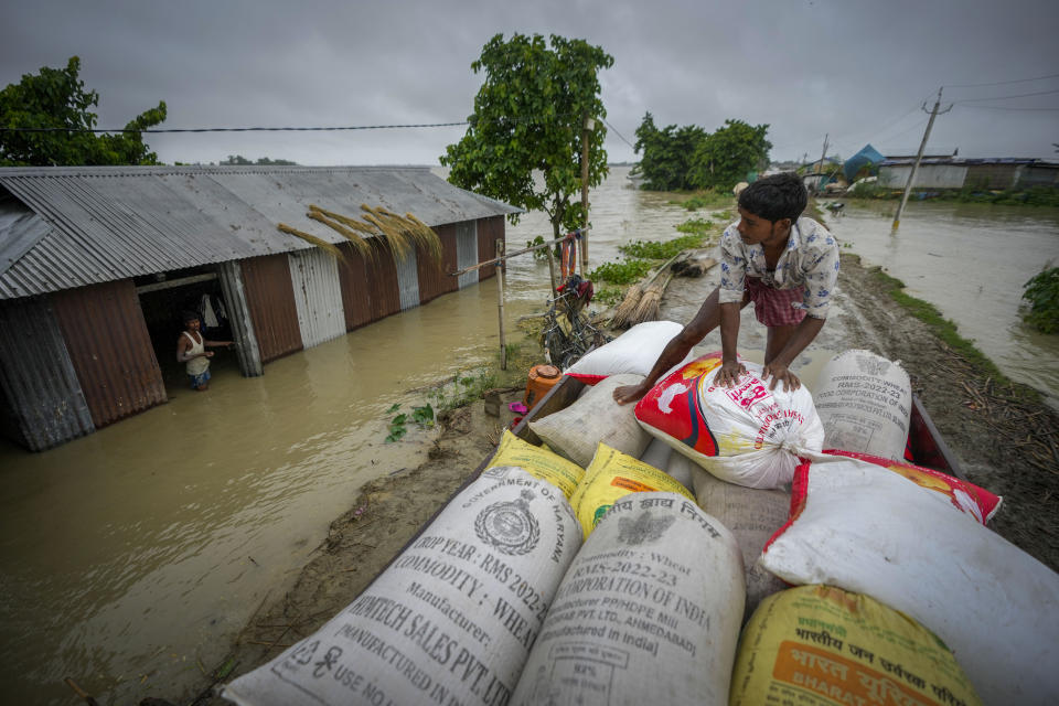 A flood affected person loads sacks of rice on a vehicle to transport to a safer place from his submerged house in Sildubi village in Morigaon district in the northeastern state of Assam, India, Tuesday, July 2, 2024. Floods and landslides triggered by heavy rains have killed more than a dozen people over the last two weeks in India's northeast. (AP photo/Anupam Nath)