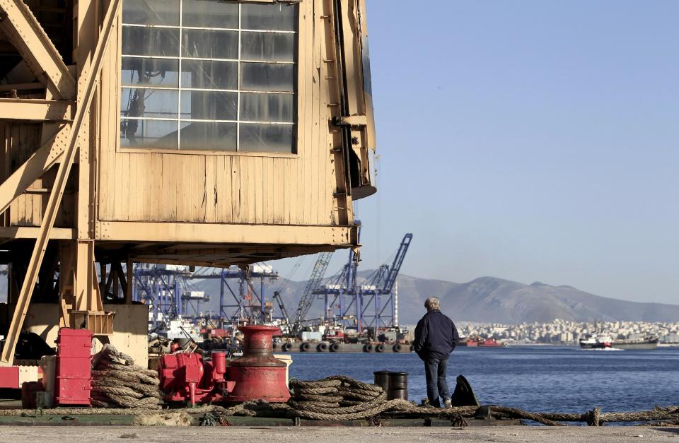 In this Monday, Feb. 10, 2014 photo an unemployed shipyards worker stands under a crane in the depressed Perama area, on the fringes of Athens' port of Piraeus. For Perama, the ships have sailed. Until recently, this working class town at Athens’ western tip hosted some of the busiest shipyards in Greece, a maritime country with one of the world’s biggest shipping industries. Perama’s unemployment is among the worst in Greece, where the nationwide figure for November was 28 percent, according to the statistical authority on Thursday, Feb. 13, 2014. (AP Photo/Thanassis Stavrakis)