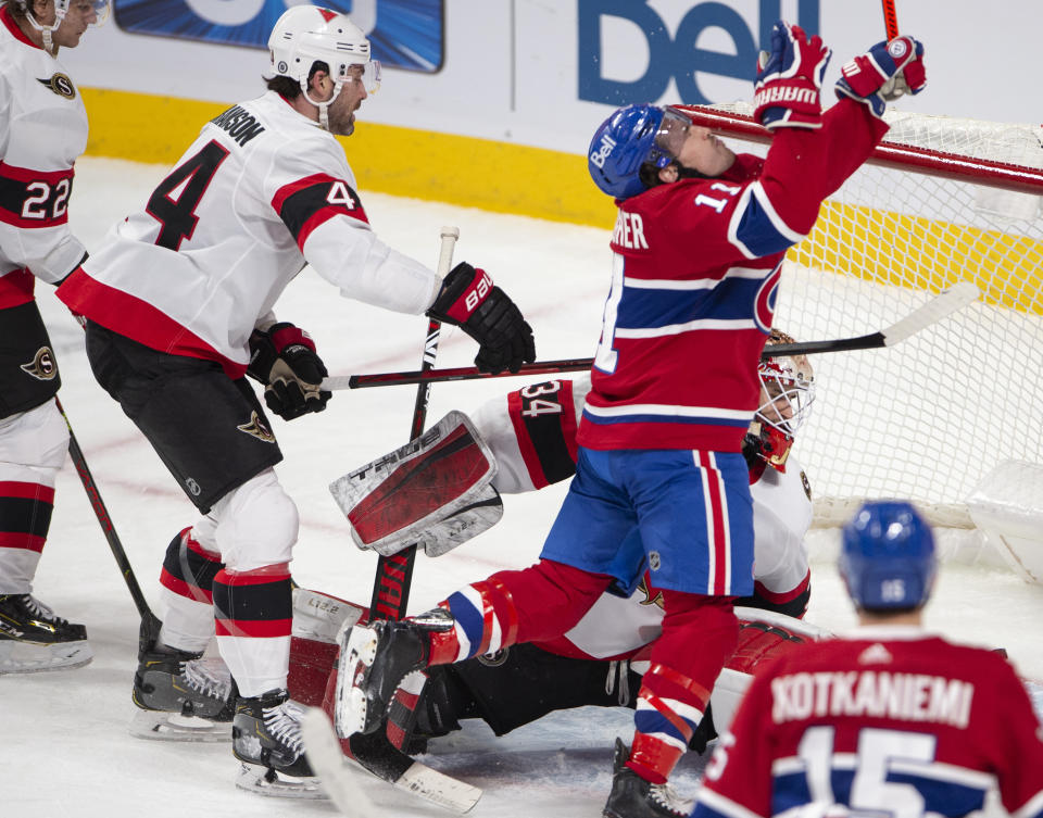 Montreal Canadiens right wing Brendan Gallagher (11) reacts to his goal, and a high stick from Ottawa Senators defenseman Erik Gudbranson (44), after scoring on Senators goaltender Joey Daccord (34) during the second period of an NHL hockey game Tuesday, March 2, 2021, in Montreal. (Ryan Remiorz/The Canadian Press via AP)