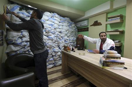 A man gestures towards sandbags piled as protection from future explosions at a stronghold of the Shi'ite group Hezbollah in the southern suburbs of the Lebanese capital Beirut January 28, 2014. REUTERS/Hasan Shaaban