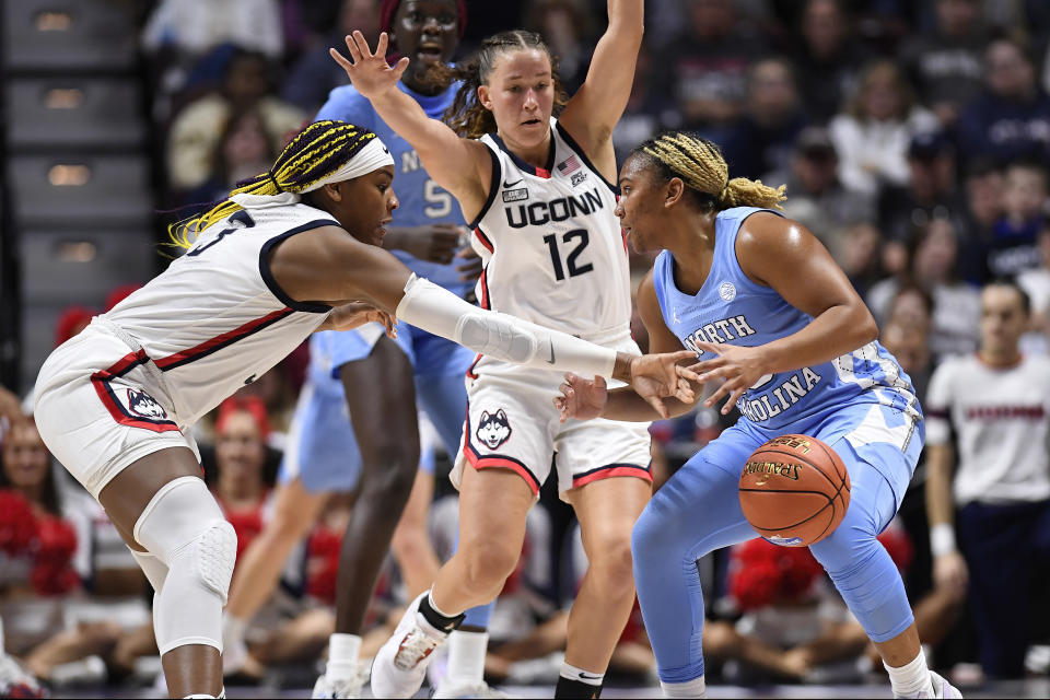 UConn forward Aaliyah Edwards, left, knocks the ball from North Carolina guard Reniya Kelly, right, as UConn guard Ashlynn Shade, center, defends in the first half of an NCAA college basketball game, Sunday, Dec. 10, 2023, in Uncasville, Conn. (AP Photo/Jessica Hill)