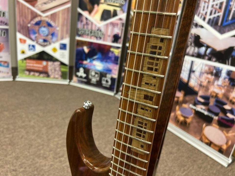 The neck of the custom Prison Blues guitar features a light wood fretboard inlay of the Oregon State Capitol.