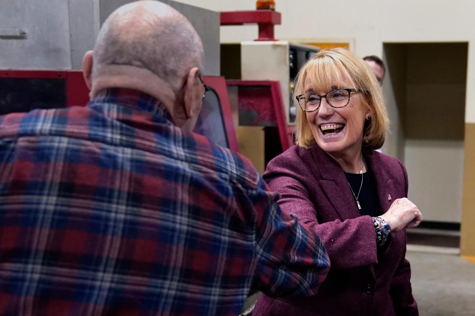 Sen. Maggie Hassan, D-N.H., bumps elbows with Roger Cloitre, left, while touring his family-owned electric products manufacturing company on a campaign stop, Tuesday, Oct. 11, 2022, in Rochester, N.H. Sen. Hassan is facing Republican Don Bolduc in the November election.