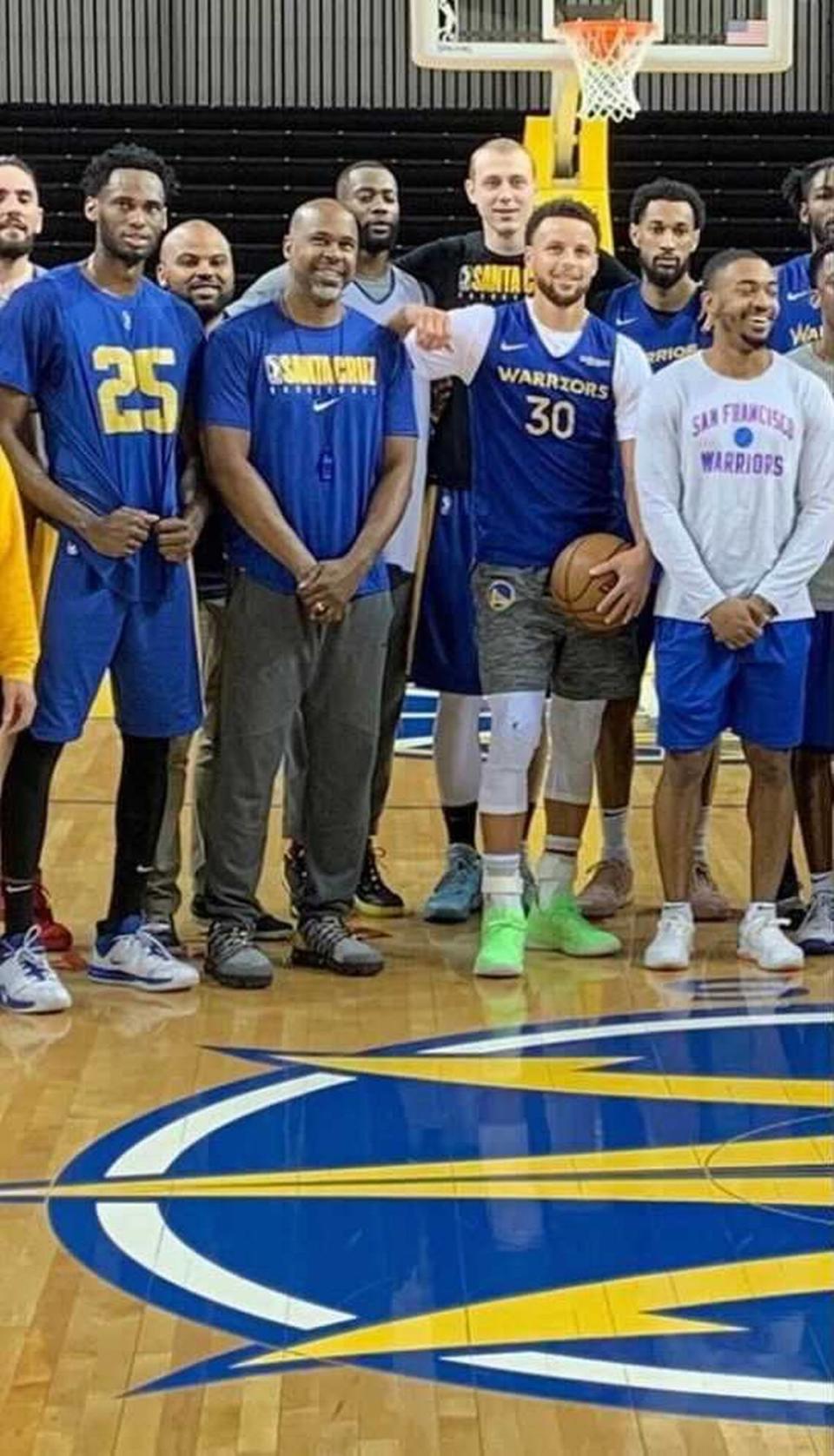 Warriors assistant coach Kris Weems (second from left, front row) takes a team photo alongside point guard Stephen Curry (third from left) and other Golden State players.