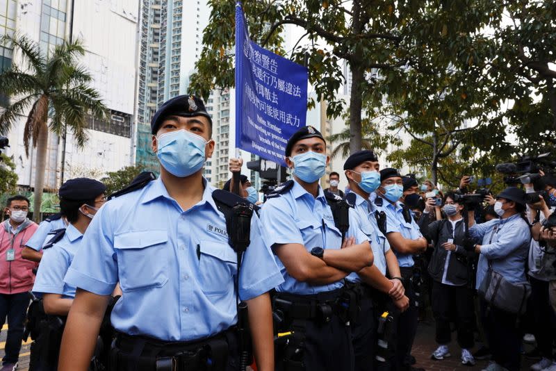 Police raise a warning flag as they try to disperse supporters of pro-democracy activists outside West Kowloon Magistrates' Courts, in Hong Kong