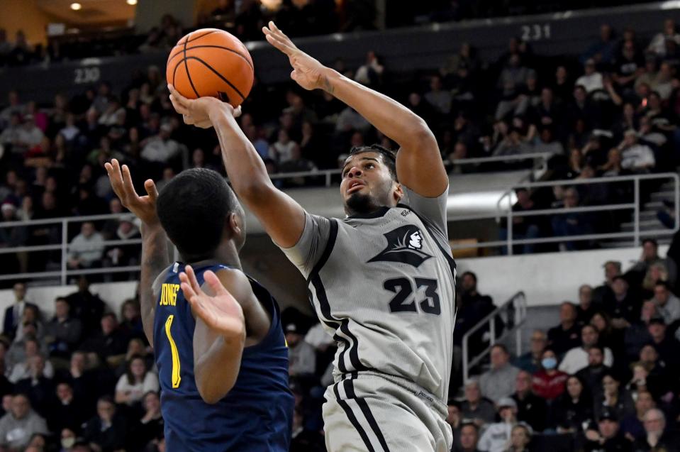 Providence's Bryce Hopkins (23) puts up the ball for a pair of points as Marquette's Kam Jones defends during overtime of an NCAA college basketball game, Tuesday, Dec. 20, 2022, in Providence, R.I. (AP Photo/Mark Stockwell)