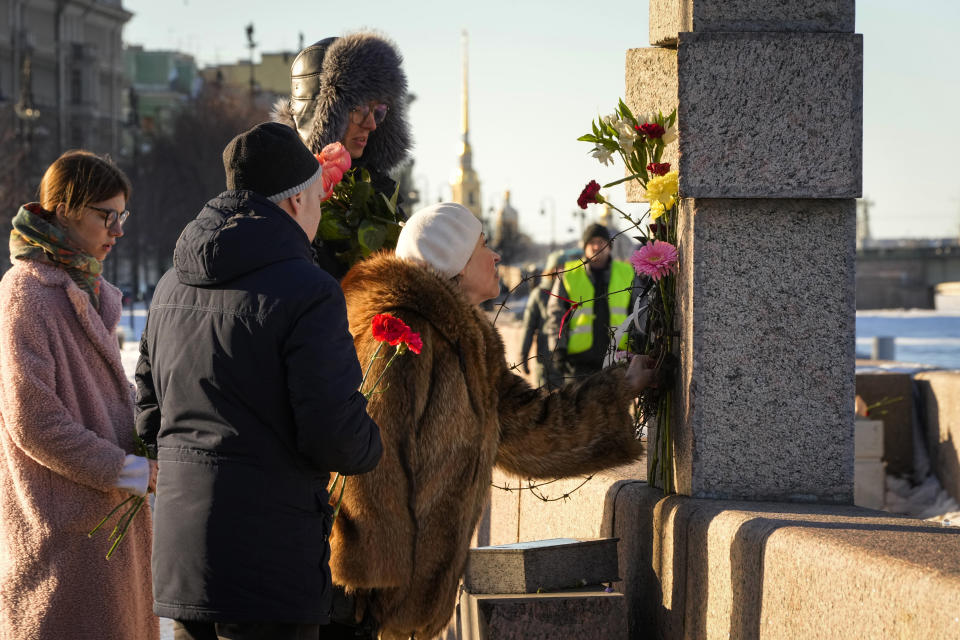 People lay flowers paying tribute to Alexei Navalny at the Memorial to Victims of Political Repression in St. Petersburg, Russia, Sunday, Feb. 18, 2024. Russians across the vast country streamed to ad-hoc memorials with flowers and candles to pay tribute to Alexei Navalny, the most famous Russian opposition leader and the Kremlin's fiercest critic. Russian officials reported that Navalny, 47, died in prison on Friday. (AP Photo/Dmitri Lovetsky)