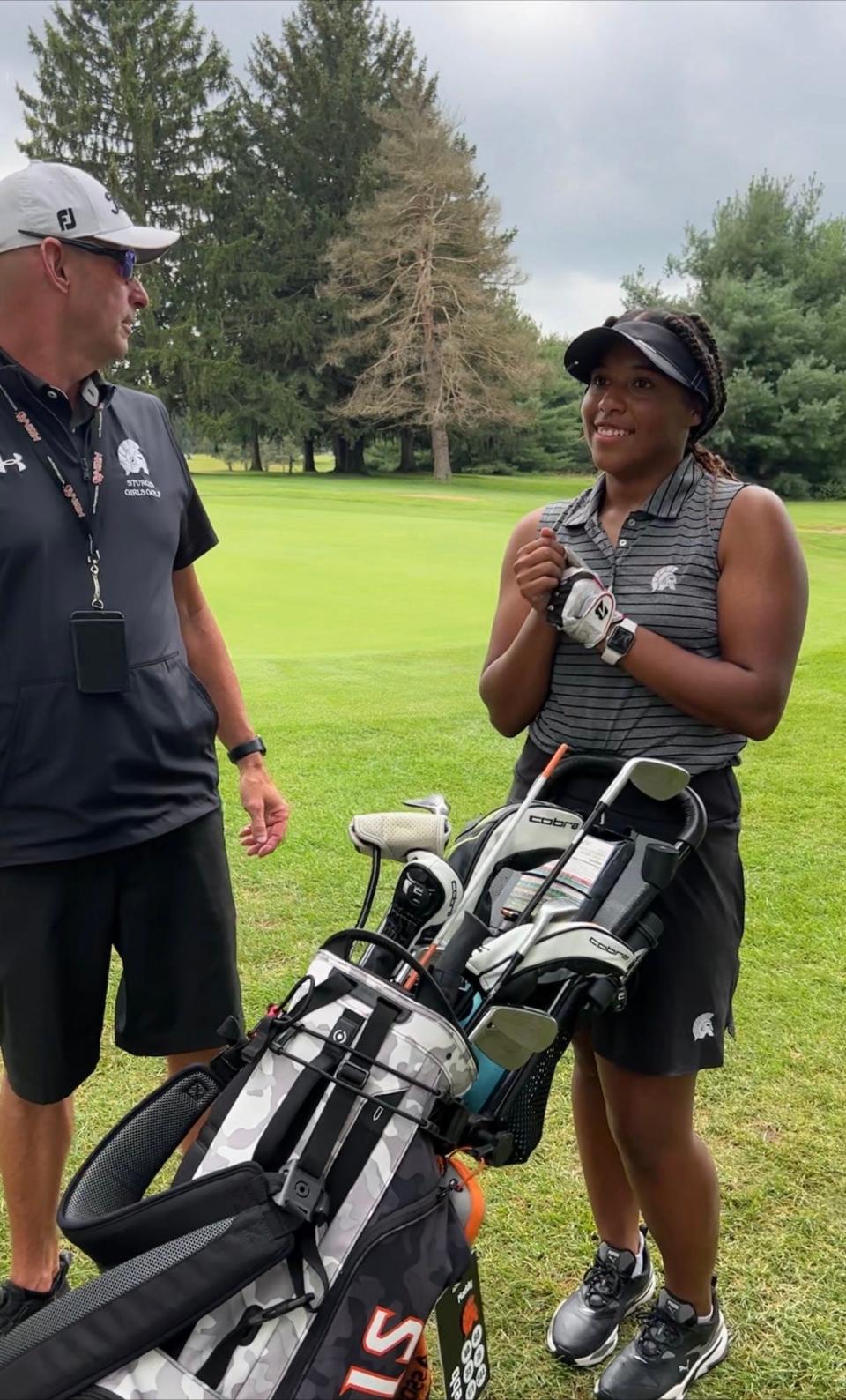 Maddy Webb chats it up with Sturgis golf coach Ken Schau in a round earlier this year.