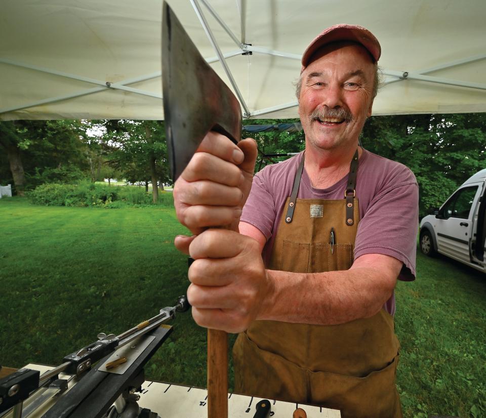Knife sharpener David Morrison demonstrate one of his axes at the Holden Farmers Market.