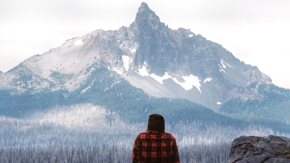 man looks at mountain