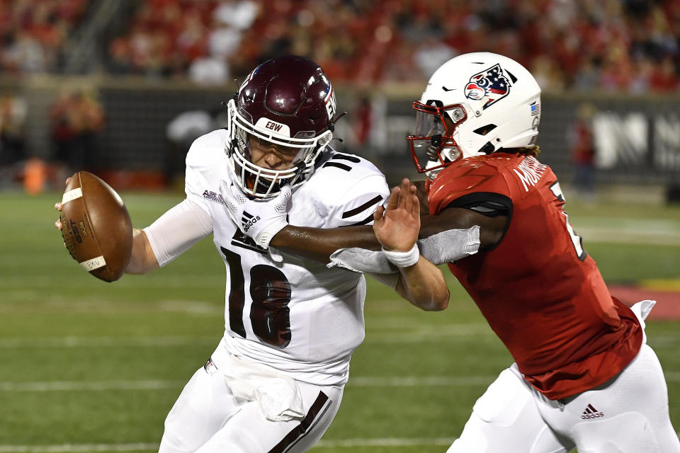 Eastern Kentucky quarterback Parker McKinney (18) is grabbed by Louisville linebacker Monty Montgomery (7) during the first half of an NCAA college football game in Louisville, Ky., Saturday, Sept. 11, 2021. (AP Photo/Timothy D. Easley)