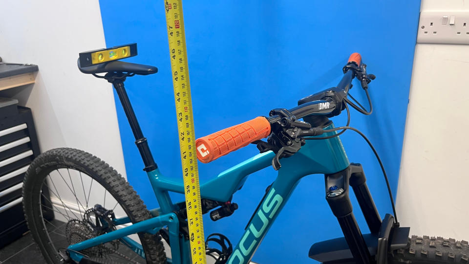 A mountain bike with a measuring tape recording the handlebar height