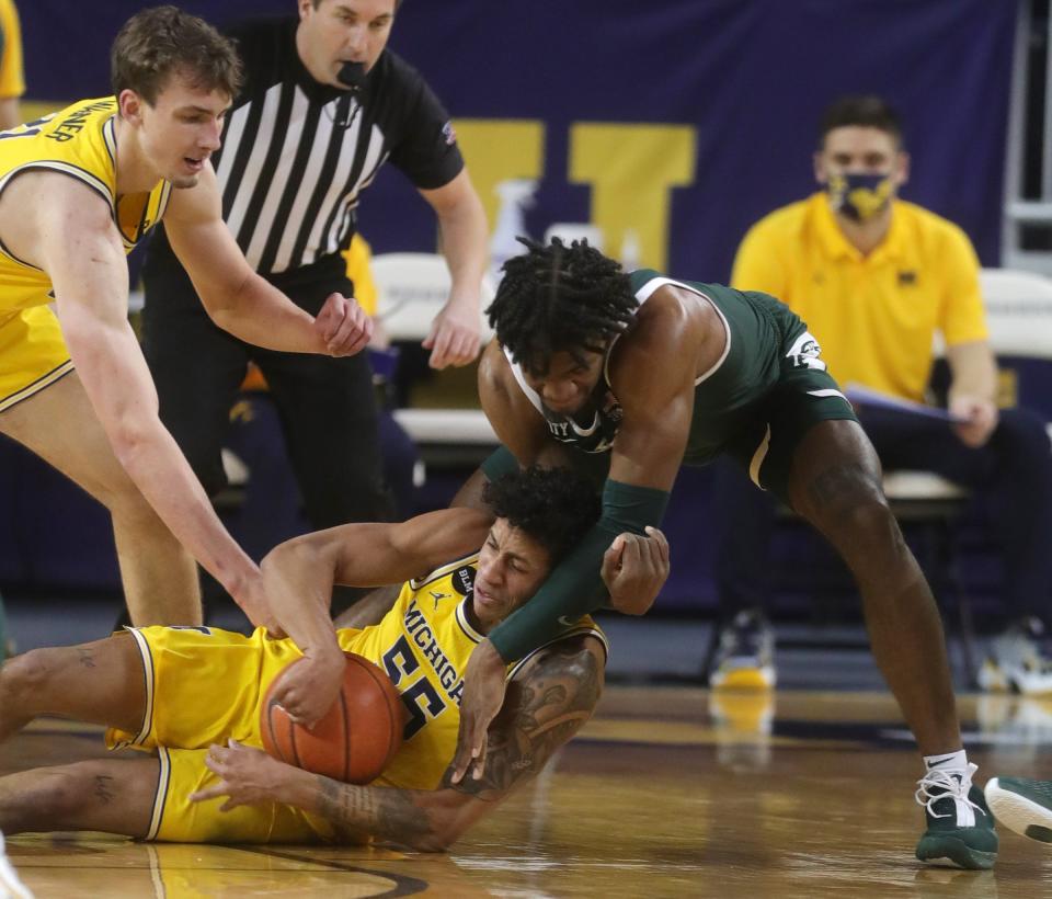 Michigan Wolverines guard Eli Brooks goes for the loose ball against Michigan State Spartans forward Aaron Henry on Thursday, March 4, 2021 at Crisler Center in Ann Arbor.