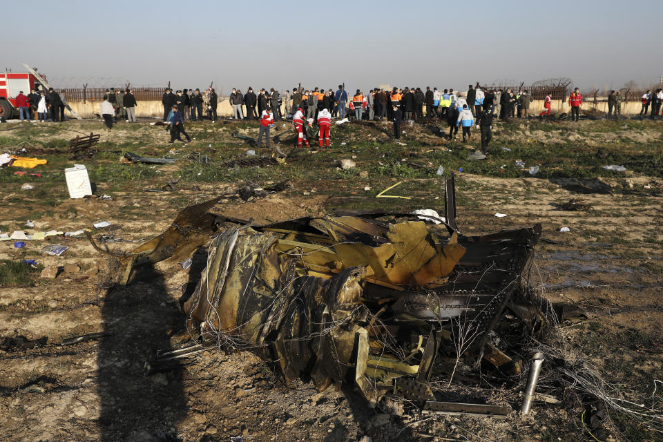 Debris is seen from an Ukrainian plane which crashed as authorities work at the scene in Shahedshahr, southwest of the capital Tehran, Iran, Wednesday, Jan. 8, 2020. A Ukrainian airplane carrying 176 people crashed on Wednesday shortly after takeoff from Tehran's main airport, killing all onboard. (AP Photo/Ebrahim Noroozi)