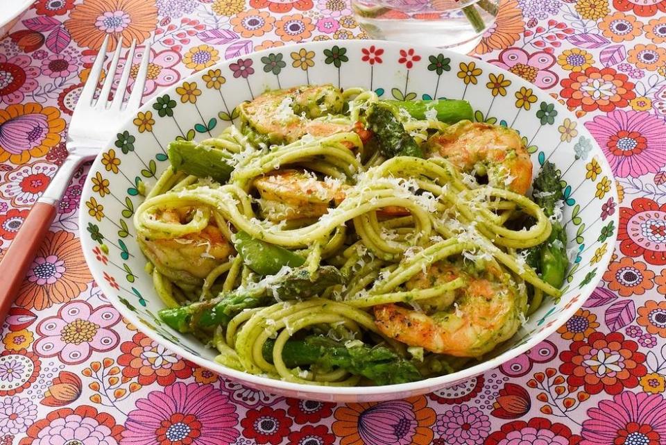 shrimp pesto pasta in bowl with pink floral background