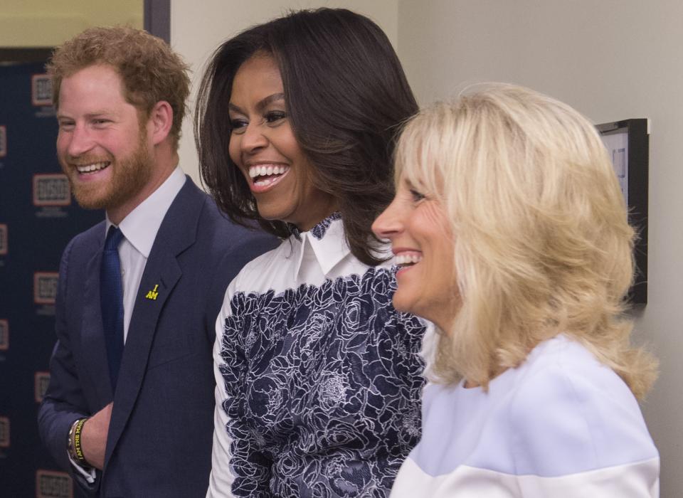 Holding his stomach Wwith Michelle Obama and Jill Biden at the Invictus Games in 2015. (Photo: SAUL LOEB via Getty Images)