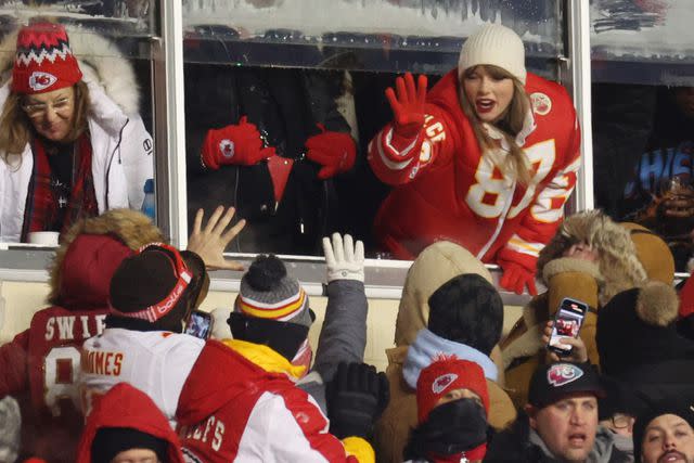 <p>Jamie Squire/Getty</p> Taylor Swift interacts with Chiefs fans on Jan. 13.