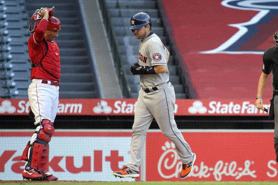 Houston Astros' Josh Reddick, right, scores as Los Angeles Angels catcher Jason Castro watches after George Springer was walked with the bases loaded during the second inning of a baseball game Friday, July 31, 2020, in Anaheim, Calif. (AP Photo/Mark J. Terrill)