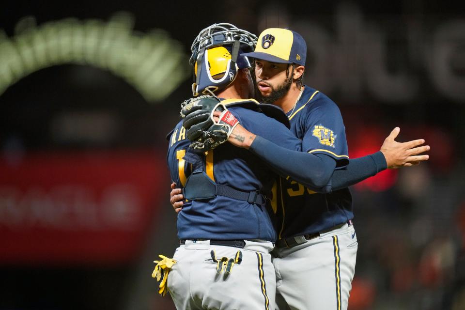 Relief pitcher Devin Williams (right) celebrates with catcher Omar Narvaez after the Brewers defeated the Giants, 3-2, on Thursday.