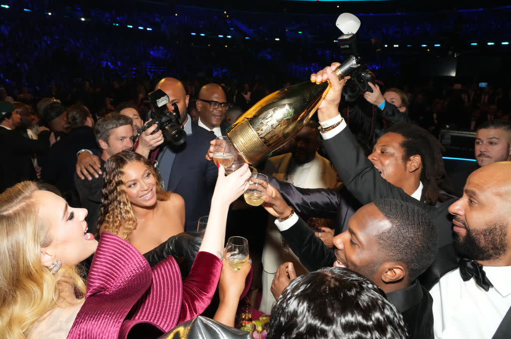 Check out these 75 pop culture trivia questions. Pictured: celebrities toasting at the 65th GRAMMY Awards. | LOS ANGELES, CALIFORNIA - FEBRUARY 05: (L-R) Adele, Beyoncé, Jay-Z, and Rich Paul attend the 65th GRAMMY Awards at Crypto.com Arena on February 05, 2023 in Los Angeles, California. (Photo by Kevin Mazur/Getty Images for The Recording Academy)