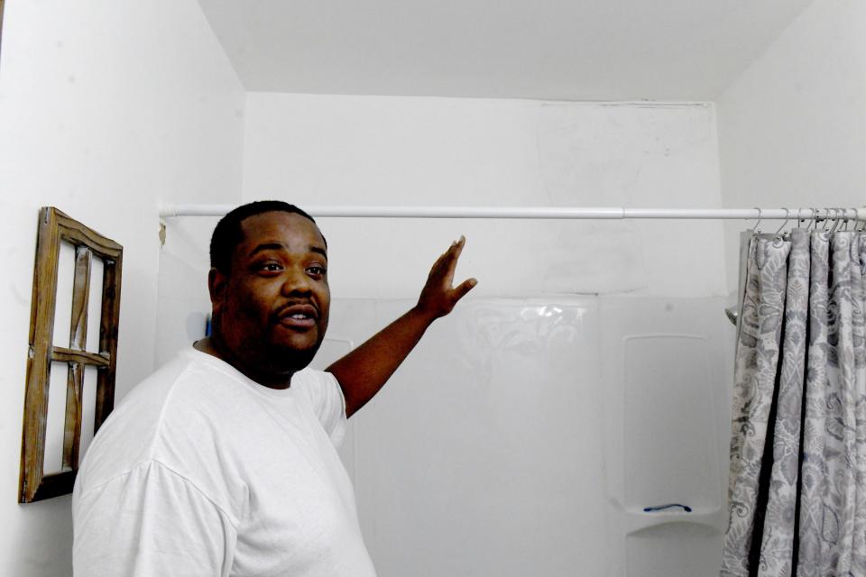 Marco Mack points to the area where feces dripped from the ceiling in their shower at Victory Square Apartments in northeast Canton. Mack is among the Victory Square tenants demanding change.